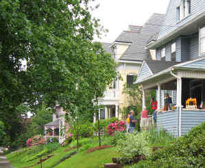Long shot of historic Kenyon Street with neighbors chatting on a porch