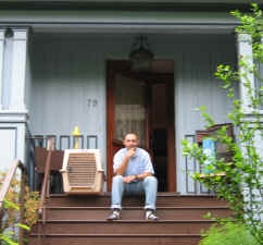 Owner with dog carrier sits on porch steps